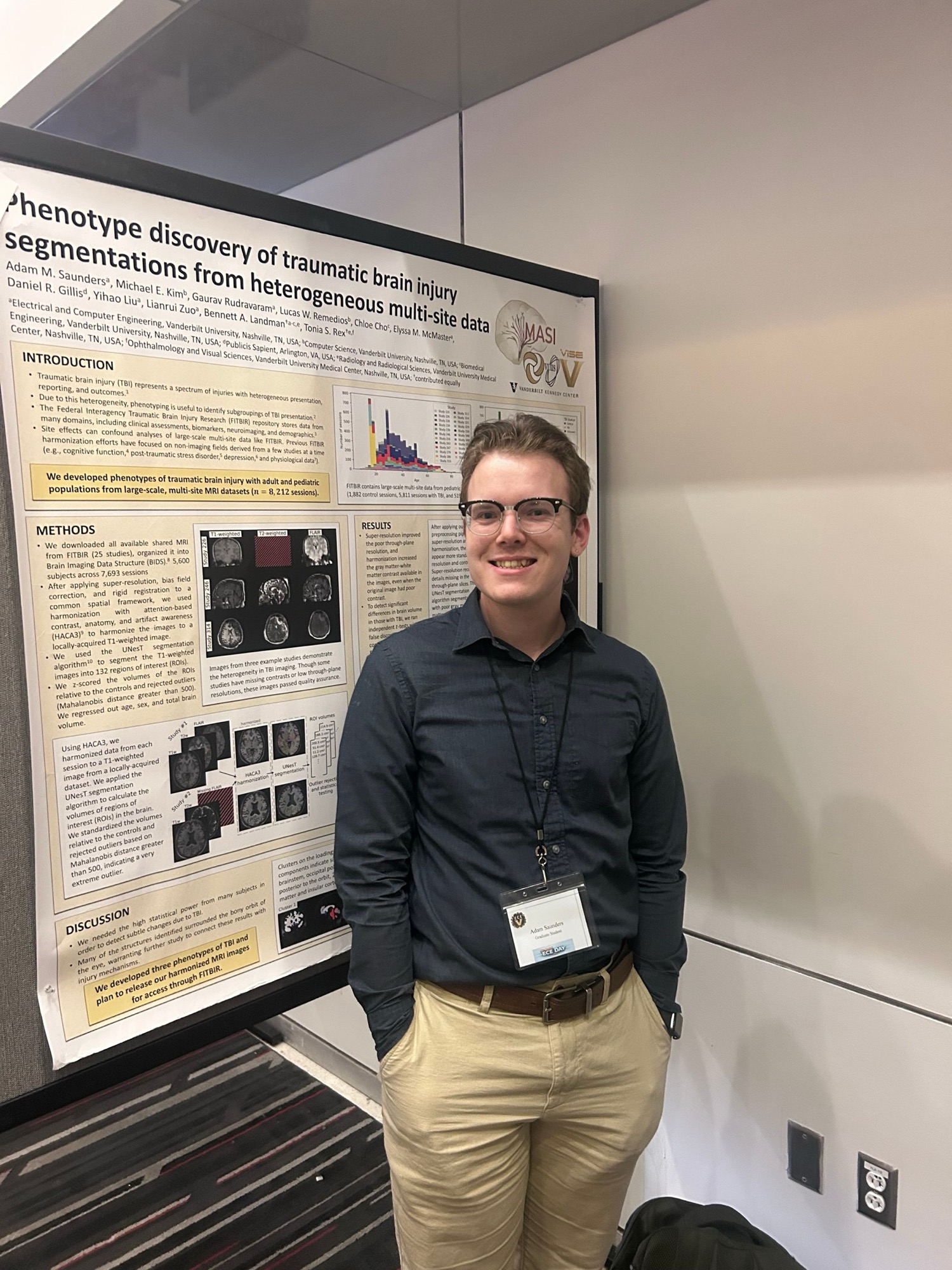 A photo of me standing next to my poster on phenotyping traumatic brain injury imaging